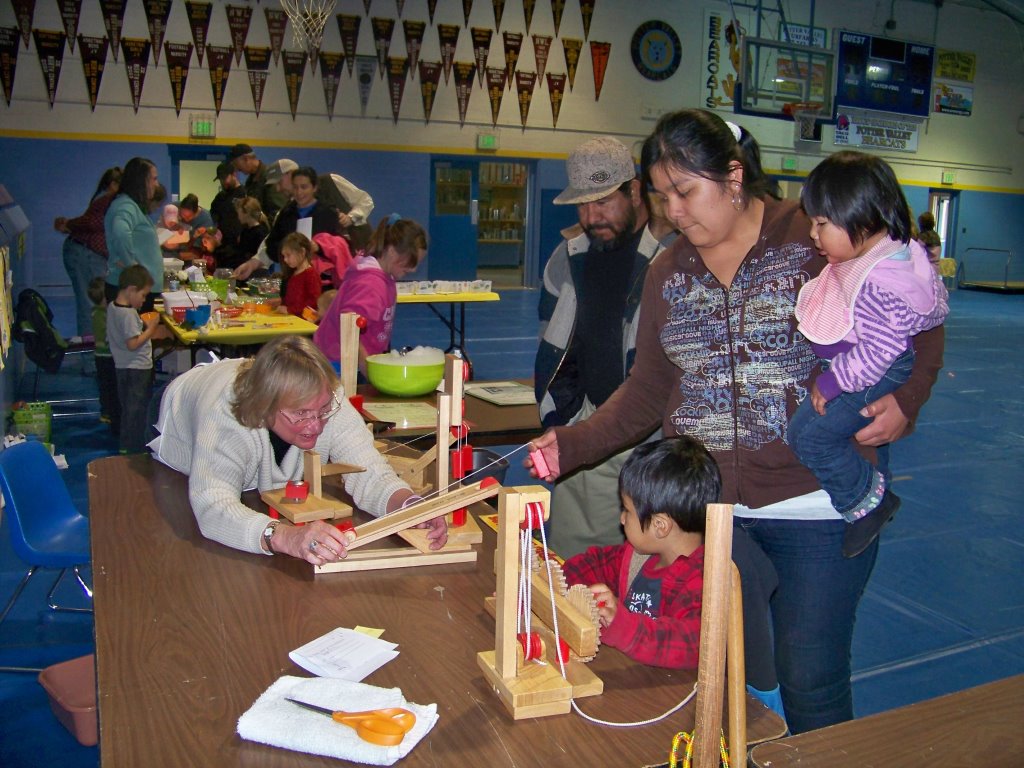 3rd grade teacher Cheri Alton demonstrates the effects of pulleys to a family during Science Night.