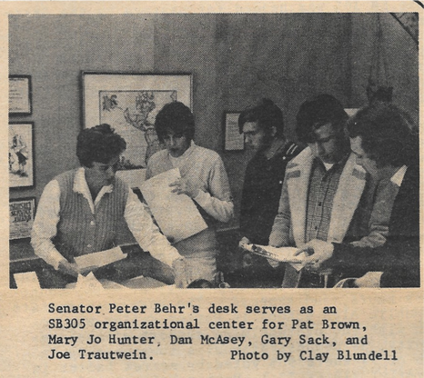 Senator Peter Behr's desk serves as an SB305 organizational center for Pat Brown, Mary Jo Hunter, Dan McAsey, Gary Sack, and Joe Trautwein.